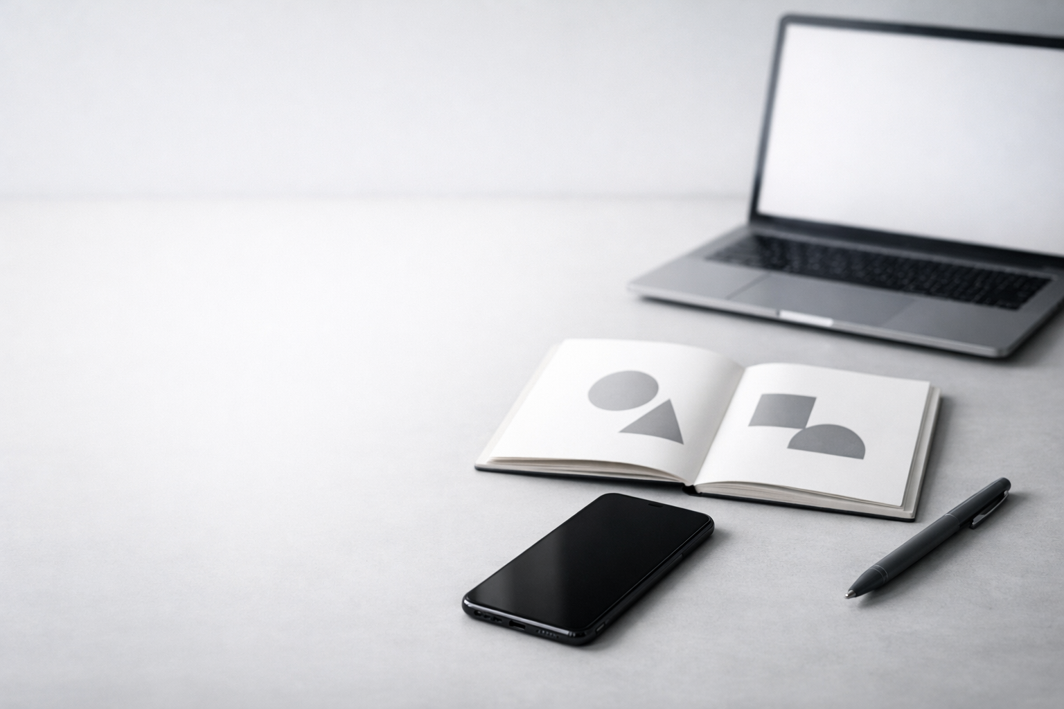 Minimalist desk with smartphone, notebook, and laptop representing a content strategy for service businesses