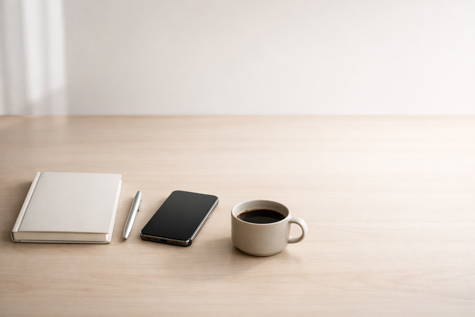 Minimal professional desk setup with notebook and phone, representing consistent brand messaging and lead quality.