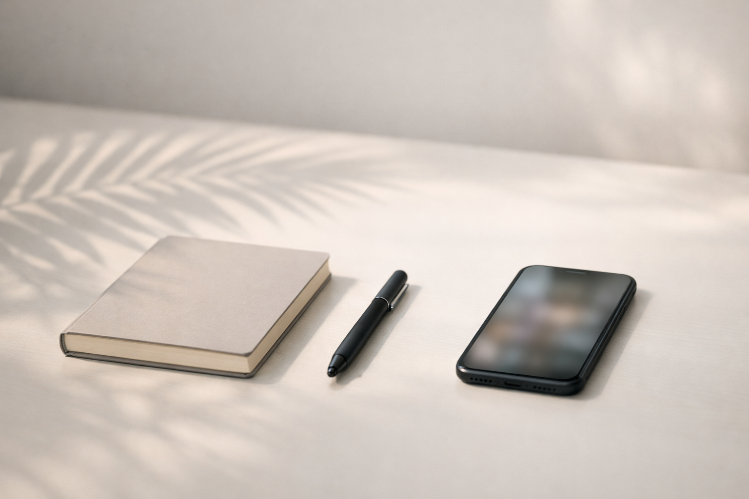 Minimal modern desk with notebook, pen, and smartphone representing building trust before a sales call